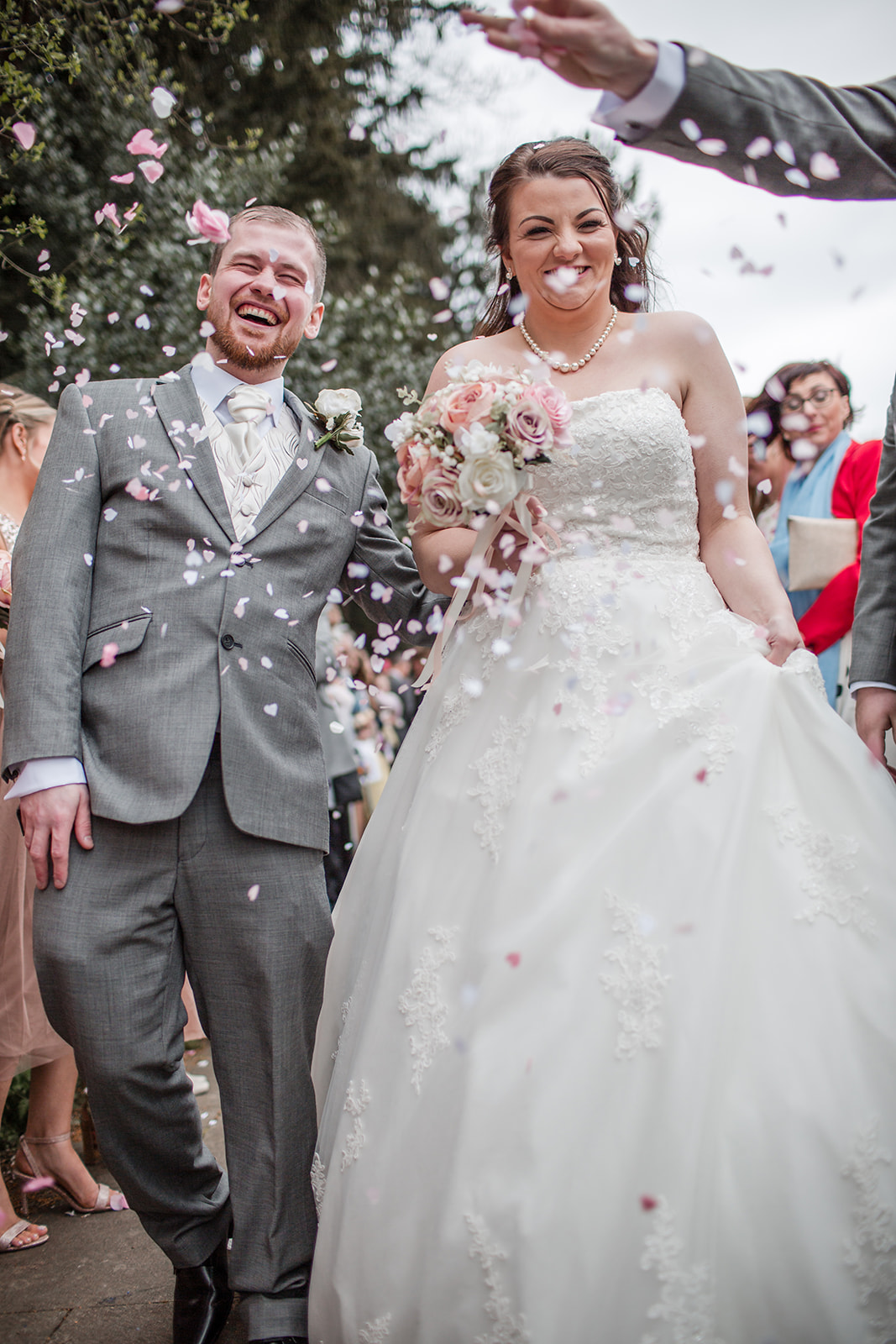 Sophie and Karl walking through confetti outside St Andrew’s Church in Laverstock, Salisbury.