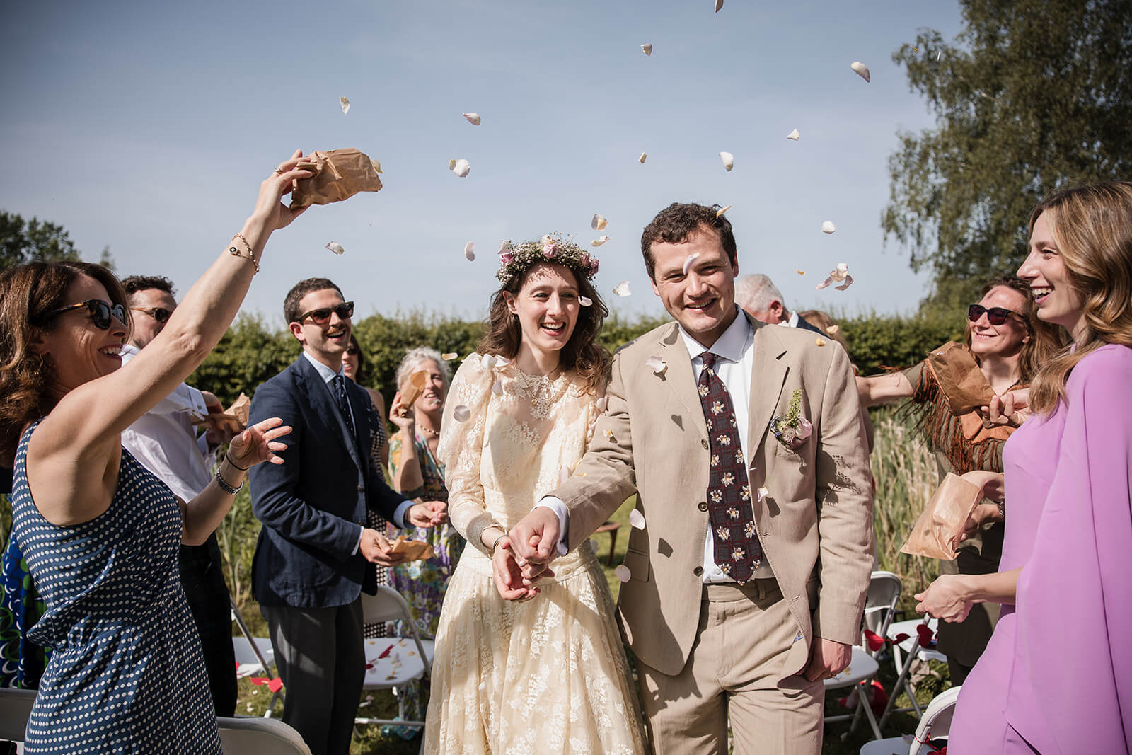 Chiara and Caius walking through confetti during their wedding near Ashdown Forest.